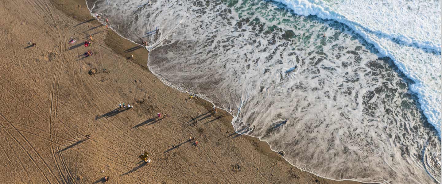 Arial view of a beach with incoming wave denoting a different perspective